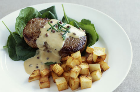 Impress with this crowd-pleasingly meaty main. Juicy steak is grilled to perfection, covered in a creamy pepper sauce and served alongside sauteed potatoes and spinach. 