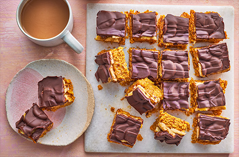 This easy snack uses just 5 ingredients! Top a peanut butter and cornflake base with bananas and melted dark chocolate for the ultimate, family-friendly sweet treat. 