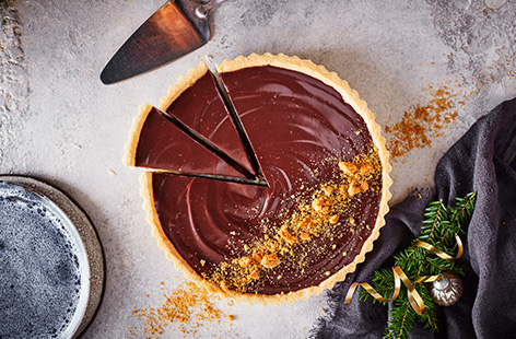 Give a rich chocolate tart a festive makeover with this gingerbread latte tart recipe. A glossy chocolate ganache has added spices and gingerbread latte liqueur on a buttery pastry base for an elegant Christmas dessert.