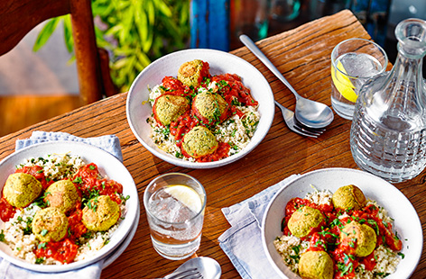 A fan of falafel? Make this hearty falafel traybake recipe for a comforting vegan dinner idea. Homemade falafel are quick to blitz together, before being baked in tomato sauce and served with herby lemon couscous.