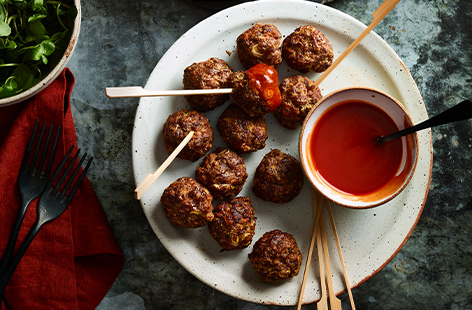 Served with ketchup and a slash of spicy buffalo sauce, these beef meatball skewers will liven up any party