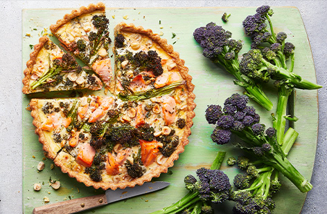 Bright purple sprouting broccoli pairs with flaked smoked salmon for a tart that makes for a fantastic Sunday lunch