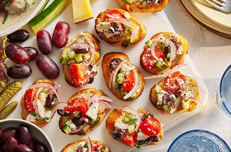 Greece meets Italy in this fresh and colourful bruschetta recipe. Top crusty baguette with feta, tomatoes and olives for big Greek salad flavours. This is perfect for picnics or any summer picky bits occasion!