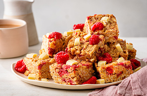 We've taken rice crispy cakes to the next level by coating them in caramelised biscuit sauce and melted white chocolate. Top with raspberries for a little tartness and leave to set in the fridge until they're crispy.
