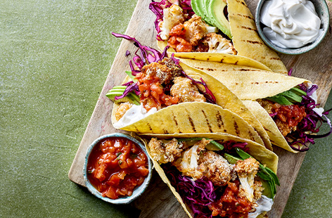 Crispy florets of cauliflower are served in tortilla wraps with a zingy cabbage slaw, avocado and salsa in this spicy taco recipe