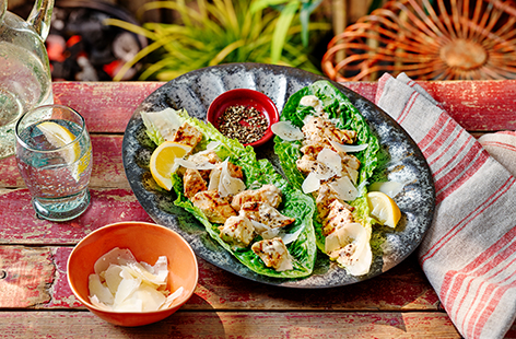 Transform a chicken Caesar salad into a new BBQ classic with this easy recipe. Marinate chunks of chicken breast in Caesar dressing before grilling and loading into crisp romaine lettuce leaves with shavings of pecorino cheese in this light and creamy dish.