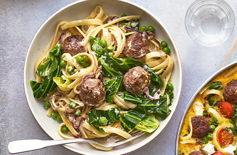 Packed with veggies to up your green count, ribbons of pasta are coated with a creamy sauce and topped with juicy meatballs