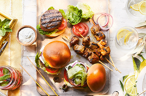Heat up the barbecue for this gorgeous Greek-style burger recipe made with Fire Pit lamb burgers topped with tomato, red onion, feta and a fresh cucumber salad.