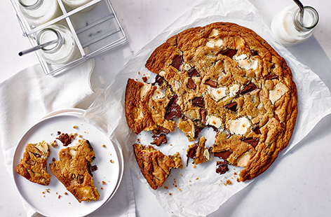 It's time to supersize your bake with this giant chocolate chip cookie recipe. Instead of rolling individual bakes, simply press the cookie dough into one large dough studded with an irresistible combination of melting milk, dark and white chocolate.