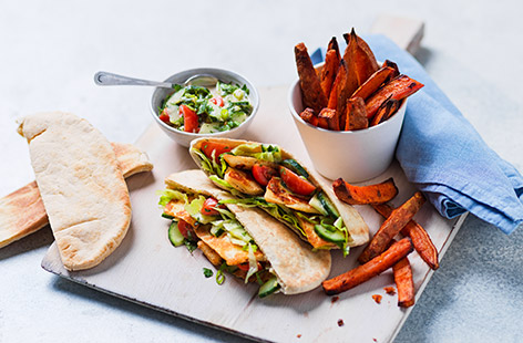 Giving Greek vibes, these pan-fried halloumi pittas are stuffed with gorgeous Med flavours and served with sweet potato wedges. A new family fave whether you're veggie or not.