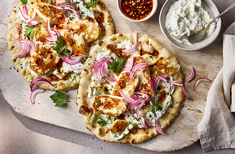 These Greek-inspired flatbreads are loaded with crispy halloumi and homemade tzatziki for a fresh and simple summer dinner. Top with pink pickled onions for zing and a drizzle of hot honey for a moreish sweet and spicy sauce.