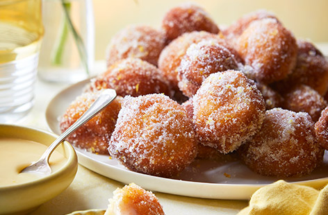 Who can resist these fluffy, sugar-coated doughnuts? We've added lemon and ricotta for a sophisticated twist – the tangy flavours work beautifully with the white chocolate dipping sauce. This recipe makes over 20 bites, so it's ideal for parties – you can even make the dough the day before.