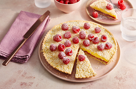 This traditional dessert recipe consists of a shortcrust pastry case topped with jam, custard and desiccated coconut. We've served ours with fresh raspberries for a juicy pop of flavour.