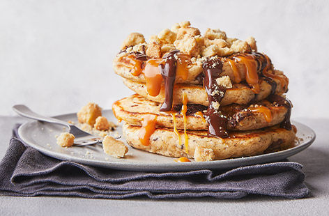 Pancake Day just got extra special. Fluffy American-style pancakes are topped with caramel sauce, melted chocolate and crumbled shortbread...yes, please!