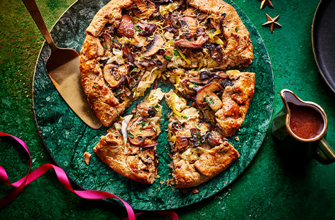 This rustic veggie tart is perfect as a Christmas dinner main or Sunday roast show-stopper. Filled with roasted mushrooms and creamy leeks, it's lovely served with red onion gravy for even more flavour.