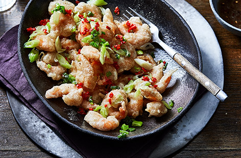Try our easy spin on the takeaway favourite of salt and pepper prawns. Coat the jumbo king prawns in a crispy seasoned batter and scattered with fresh spring onion and fiery red chilli.