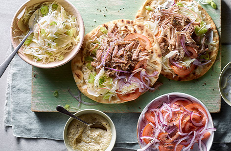 Slow-cookers aren’t just for winter! Try this recipe for pulled pork souvlaki flatbreads, with tzatziki and slaw. 
