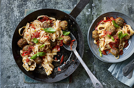 Make a dinner to remember with a heaping portion of pesto meatballs in a spicy tomato sauce served over al dente tagliatelle.