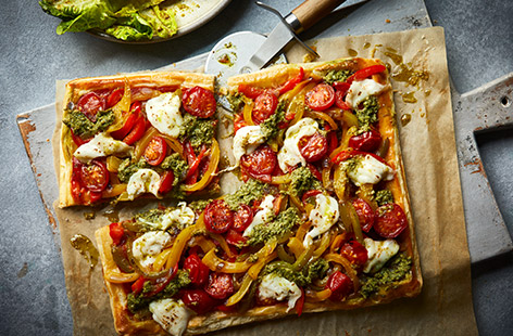 Serve up homemade pizzas in flash with this cheat's puff pastry version. We've topped ours with cherry tomatoes, peppers and mozzarella but you can customise it with your family's favourite toppings. Serve with a fresh lettuce salad for a speedy meal the whole family will love.