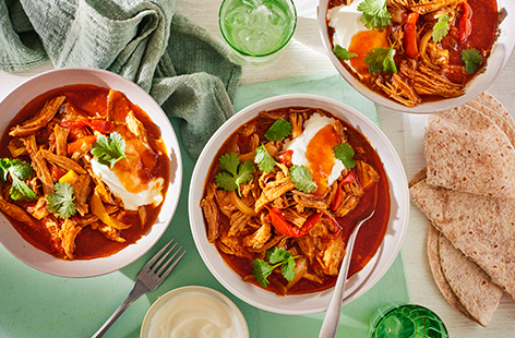 Switch out your Indian takeaway with this tasty slow-cooked pork dish instead. Pork shoulder is slow cooked in a fragrant homemade curry paste and coconut milk before being shredded and served with warmed flatbreads, yoghurt and tangy mango chutney in this warming recipe.