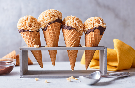 Pep up that box of rice crispies lurking in your cupboard with this fun coconutty recipe. Rice crispies are combined with melted butter, coconut cream, honey and desiccated coconut before being shaped into ice cream scoops and placed in a chocolate dipped cone. 
