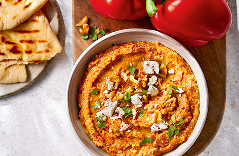 This vibrant Middle Eastern dip is made with walnuts and grilled red peppers. Garnish with tangy feta and serve with warm pitta bread for a tasty side or snack.