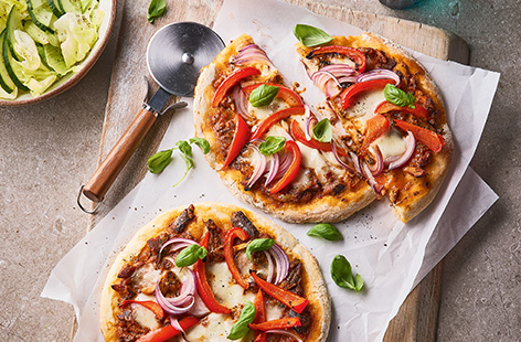 These easy homemade pizzas are made with a 2-ingredient dough that comes together in minutes. Kids can help build their pizzas with their favourite toppings, we recommend salty sardines with peppers and red onion. 