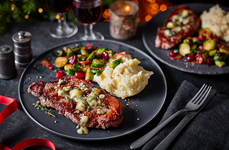 Molten blue cheese elevates sirloin steaks to a luxurious meal for two while balsamic Brussel sprouts and horseradish mash are the ultimate accompaniments.