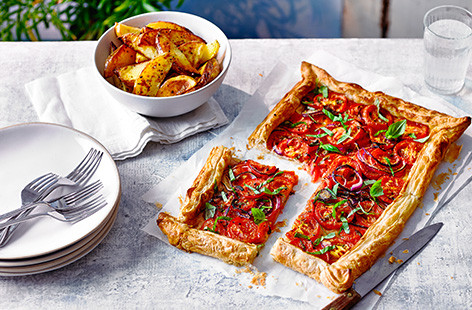 Make this simple tomato galette recipe for an easy summer dinner. Perfect if you've bought or grown too many tomatoes, this easy bake is served with homemade potato wedges for a new vegan dinner idea.