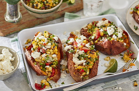 These aren't any ordinary spuds... These colourful sweet potato jackets pack a flavourful punch - they're topped with a herby and zesty corn salsa and finished with a sprinkling of salad cheese