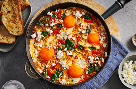 Warm chilli and tomato sauce meets peppers, spinach and feta in this lazy baked eggs dish, which takes just 20 minutes to make