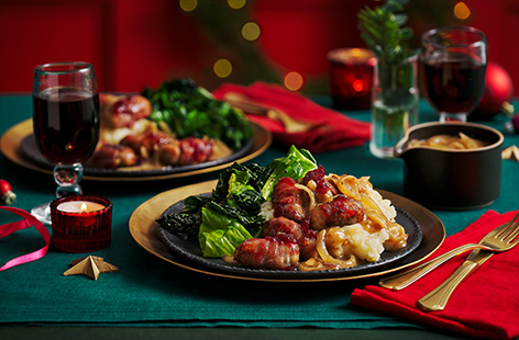 Transform classic sausage and mash into a festive family favourite with pigs in blankets and a generous pour of onion gravy.