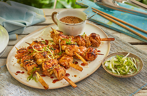 Marinated chicken thighs are threaded onto a skewer with chunks of spring onions and barbecued until golden and slightly charred