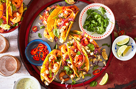 Try something different for a Mexican dinner with these spicy prawn tacos. Creamy garlic and herb cheese makes these extra special - blitzed into a creamy avocado sauce and then sprinkled on top to balance out spicy prawns and a crisp veggie slaw.