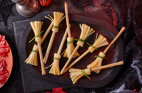 Make the perfect spooky snack or Halloween party nibble with this simple 3-ingredient cheese straw broomstick recipe. Use breadsticks as a broom handle, string cheese as the brush and tie with a pop of green chives.