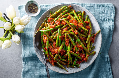 Transform green beans into a delicious Easter lunch side dish. With a garlic and tomato sauce, these beans are bound to be a hit with your guests. 