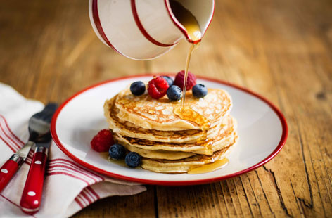 Classic American pancakes are piled high and best served with a drizzle of maple syrup – you could also add crispy bacon and blueberries, if you like. This easy fluffy pancake recipe ticks all the boxes - perfect for Pancake Day, a satisfying breakfast or a weekend brunch treat. Roll up your sleeves and learn how to make American-style pancakes like a pro!