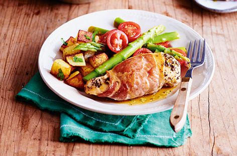 Make chicken breasts all the more flavoursome by coating in fragrant Italian herbs and wrapping in salty bacon before roasting until crisp and golden. Served with a asparagus and tomato salad, this easy chicken recipe is sure to become a firm favourite