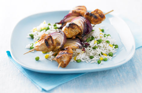 These chicken and red onion skewers are marinated in olive oil, lemon juice and Cajun spices before being griddled until cooked and juicy. Serve with fluffy rice, peas, sweetcorn and some chilli sauce on the side.