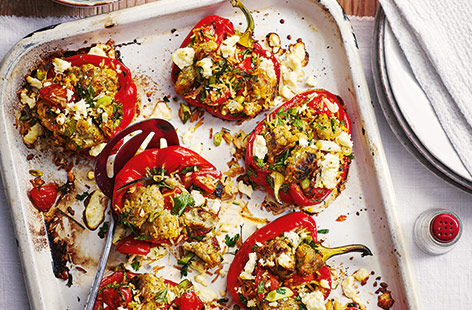 Load up peppers with the stuffing, tomatoes, rice and spring onions and finish with parsley and crumbly Greek salad cheese.