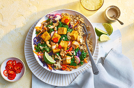 A bowl of goodness with bite! Brown rice is topped with marinated spiced tofu, plenty of veggies, toasted cashews and finished with a tahini dressing. 
