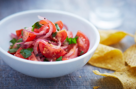 Homemade salsa is a perfect dip for tortilla chips, or alongside grilled meat and fish at a barbecue. Here juicy cherry tomatoes are combined with chilli, lime, and red onion for a result that's a real crowd pleaser. Add fresh basil and parsley for an aromatic lift.