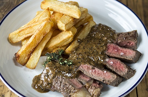 Deliciously tender ribeye steaks are served with a creamy peppercorn sauce and tasty twice-cooked chips in this simple recipe