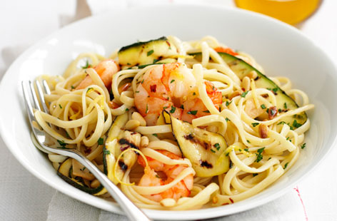 This summery pasta dish makes a great speedy midweek meal. Griddling the courgettes gives them a smoky edge, which is perfect with the juicy prawns and crunchy pine nuts. Add a little bit of heat with a pinch of chilli flakes.
