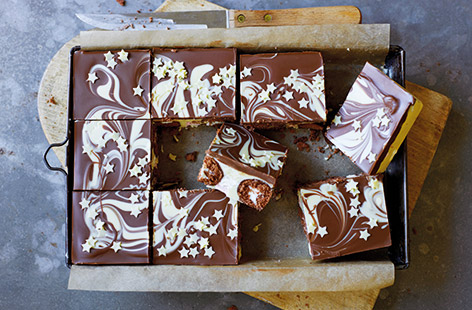 Got a seriously sweet tooth? This chocolate mini roll sheet cake is the recipe you need – with soft chocolate mini rolls covered in white chocolate and marshmallows, topped with a white chocolate swirl. Perfect for picnics or an afternoon treat.