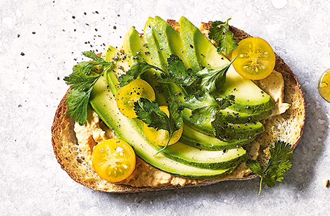 Avocado on toast gets a colourful makeover in this quick and easy toast topper, with creamy houmous, yellow tomatoes and zesty coriander