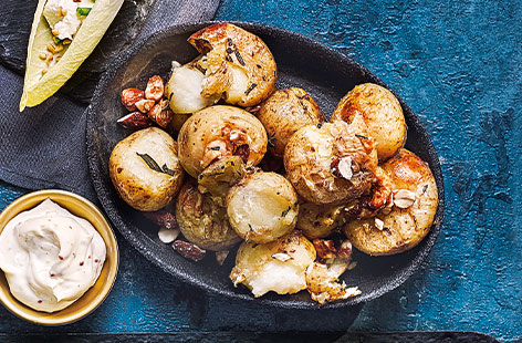 Mini roast potatoes, with a sprinkling of salty-sweet nuts and mustard mayo for dunking, make the most moreish party food idea