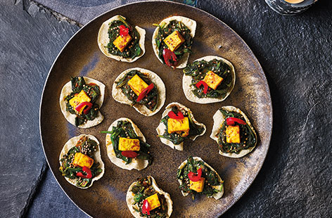 Satisfyingly simple, guests will love these poppadom bites, topped with turmeric and tikka-spiced paneer and spinach, and garnished with mustard seeds and a little sliced red chilli