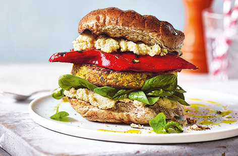 Keep everyone happy at your next barbecue with this vibrant spiced veggie burger recipe. Chickpeas, cauliflower couscous and dried apricots are blitzed into juicy patties and layered up with smoky charred peppers and creamy houmous.
