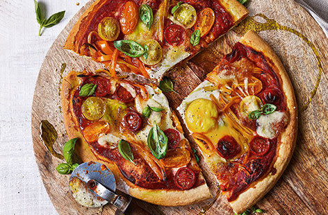 Transport yourself to the Mediterranean with this colourful veggie pizza, topped with a rainbow of sweet tomatoes, tangy peppers and a sunny baked egg